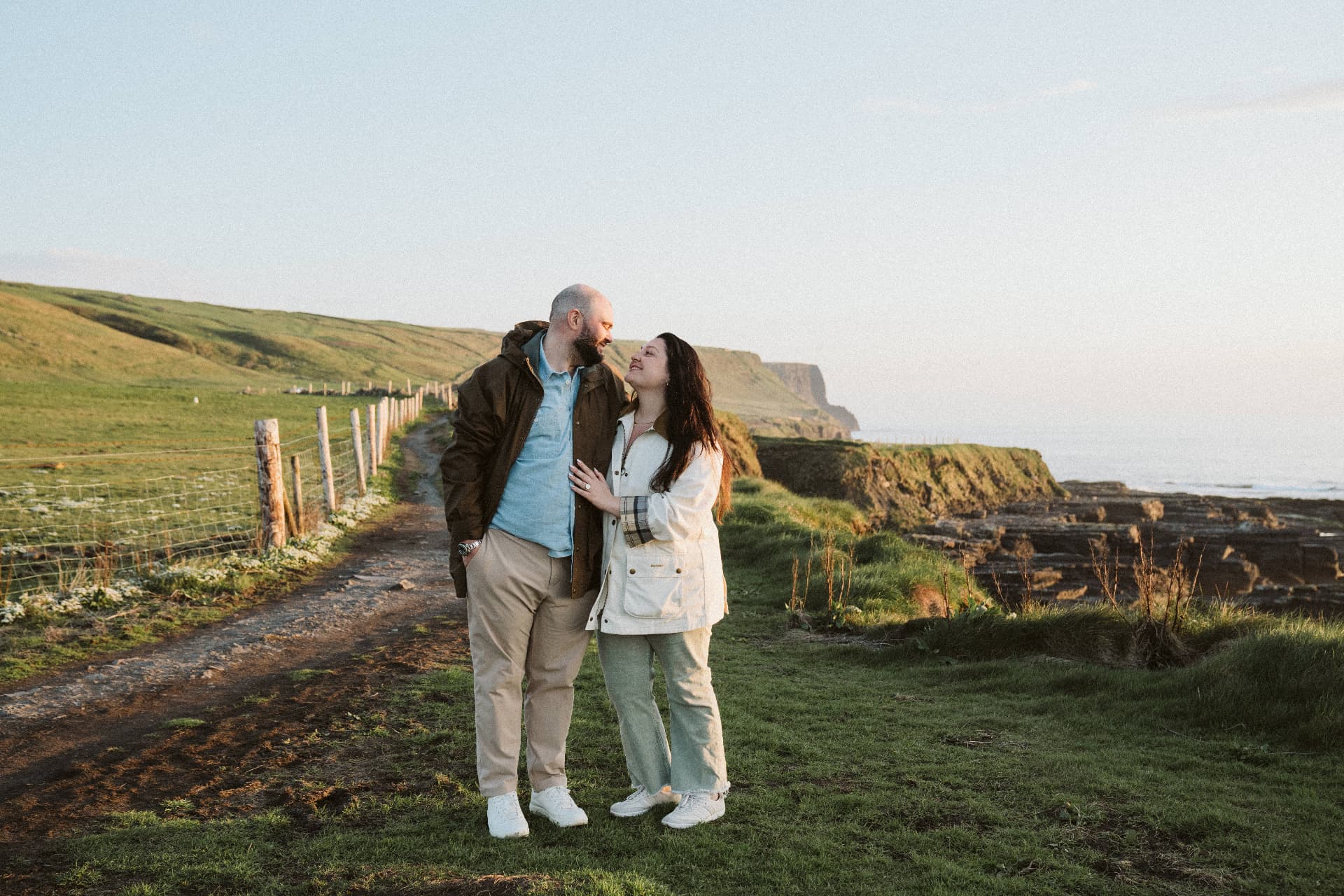 Jaime and Nolan on a coastal path at sunset