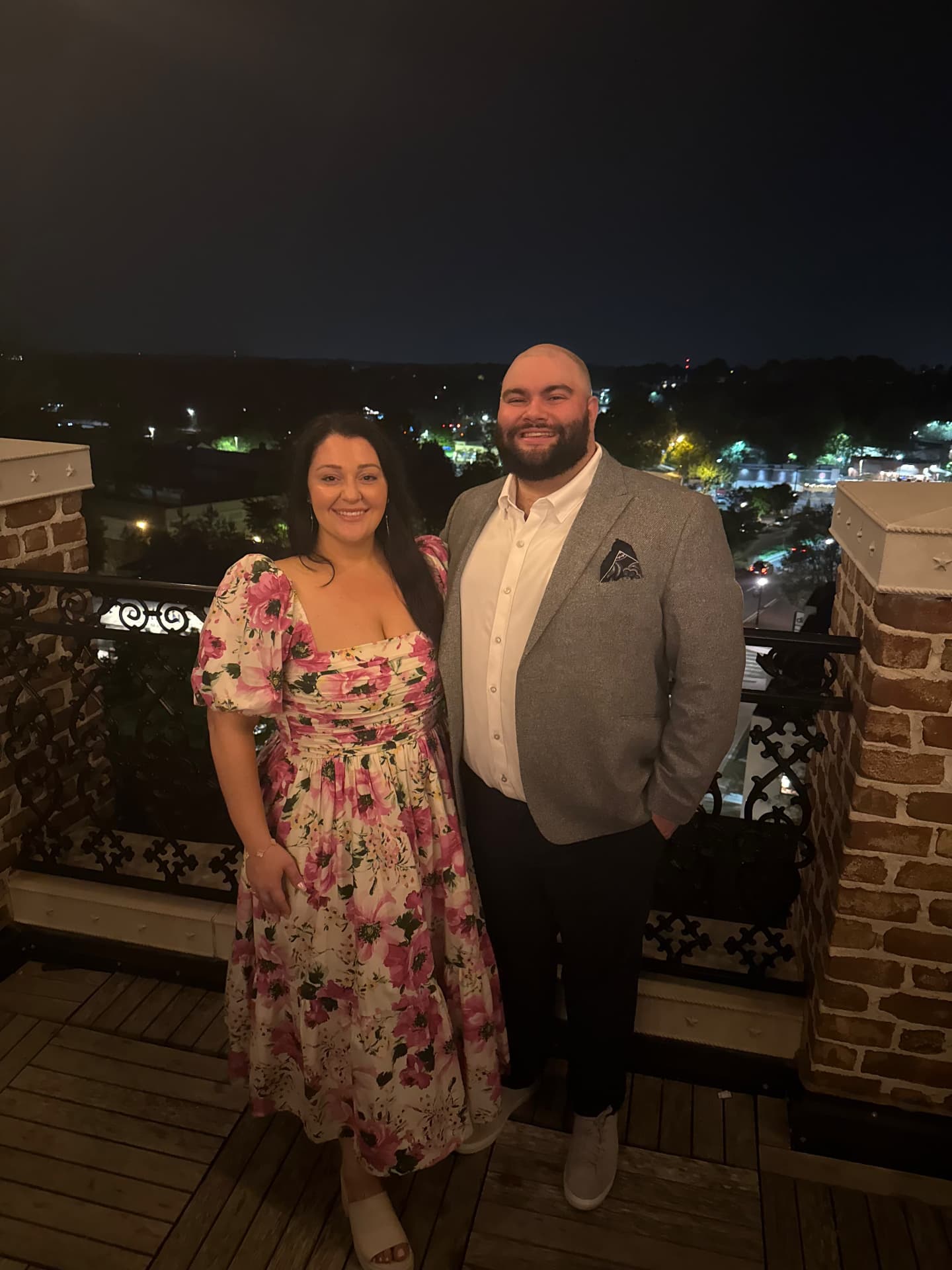 Jaime and Nolan dressed up on a rooftop balcony at night